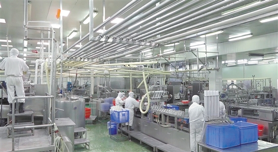 工人們正在生產(chǎn)線上緊張忙碌著，機(jī)械裝置也在有序高效作業(yè)。